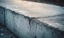 a wall covered with water drops and a cement slab