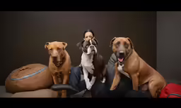 a beautiful woman sitting between three dogs
