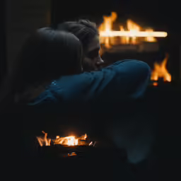 a young couple sitting in front of fire