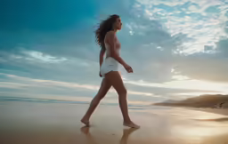 woman walking along the shore line at sunset