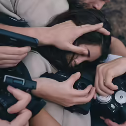 several people taking pictures of someone holding a camera