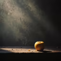 an apple on top of a wooden surface next to a light