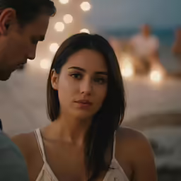 a woman standing next to a man near lights