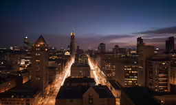 some very tall buildings at night near lights