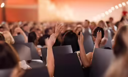 the people are sitting in the seats with their hands up