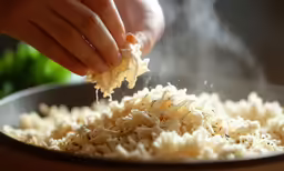 person is adding flour in a bowl that is full of something