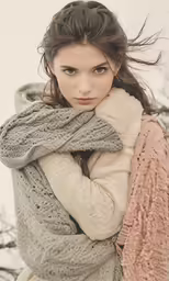 a woman in a knit scarf is holding onto the ground