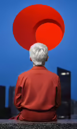a man with a red circular head in front of buildings