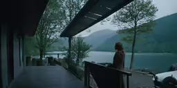 a person standing on a porch by the water