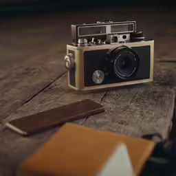 a vintage camera sitting on a wooden table next to a book