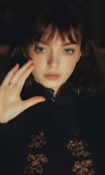 a girl in black shirt touching her face