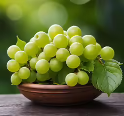 a small dish of green grapes and leaves