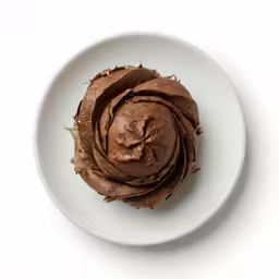 chocolate cupcake on white plate with sprinkled frosting