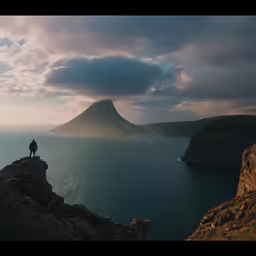 a person standing on a cliff overlooking the water