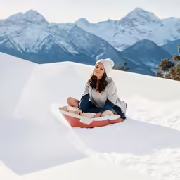 a woman on a sled looking off in the distance