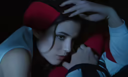 a woman is sitting with her arm wrapped around her head