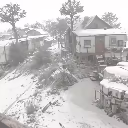 an old house sitting on top of snow covered hillside