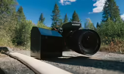 a camera sitting on the ground next to trees