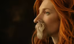 this woman has very long red hair and a beard