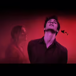 a man standing next to a woman in front of a red background