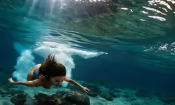a woman is diving in the ocean water