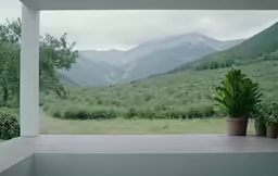 a large window has view of a green mountain range