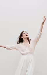 a woman in a white blouse holds out her arms
