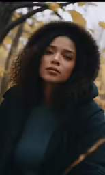 a woman in a black jacket looking at the camera