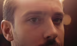 a man with a mustache is staring into the distance