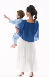 a little girl holding a doll that is wearing a blue shirt
