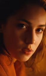 a woman with long hair and orange sweater