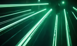 a tunnel of green lights that are in a dark room