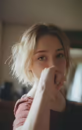 a young woman posing with her finger under her nose