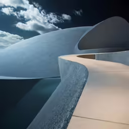 an outdoor fountain has a curved structure