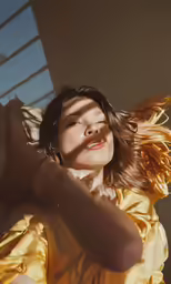 woman in a yellow dress with her hair in the wind