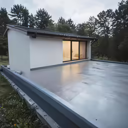 an empty house with a white roof in the day