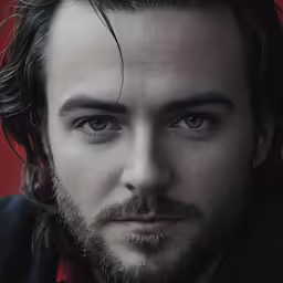 a man with a beard stares directly at the camera