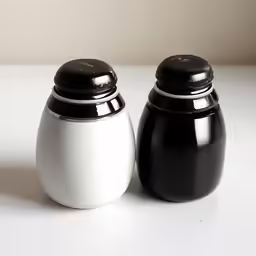 two black and white jars sitting on top of a table