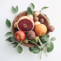 a wood bowl filled with various types of fruit