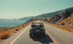 two people in an open convertible riding on a road