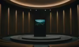 the television is sitting on a podium in front of a row of seats