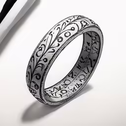 a silver wedding ring with black lettering on it