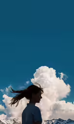 a young woman standing in the snow holding a kite