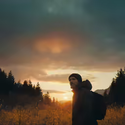 the sun is setting in the sky with trees and grass