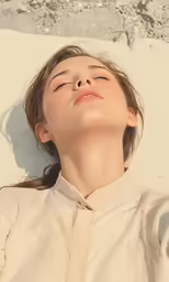 a young woman laying down on a sandy beach