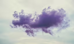 an airplane is flying through the clouds above the water