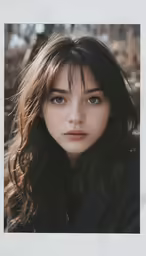 a woman with long dark hair and blue eyes looks at the camera
