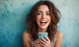 a woman smiles while looking at her cell phone