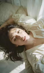 a woman laying in bed under a blanket