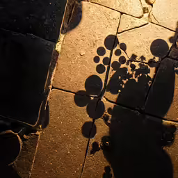 the shadows on the pavement look like balls